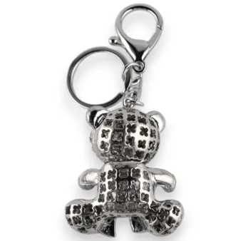 Silberner Schlüsselanhänger mit roter Schleife in Form eines Teddybären