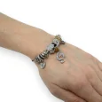 Silver and brown rigid charms bracelet with treble clef