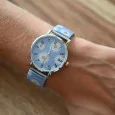 Montre Ernest Marguerite blanc sur fond bleu ciel