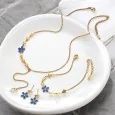 Golden steel jewelry set with blue flowers