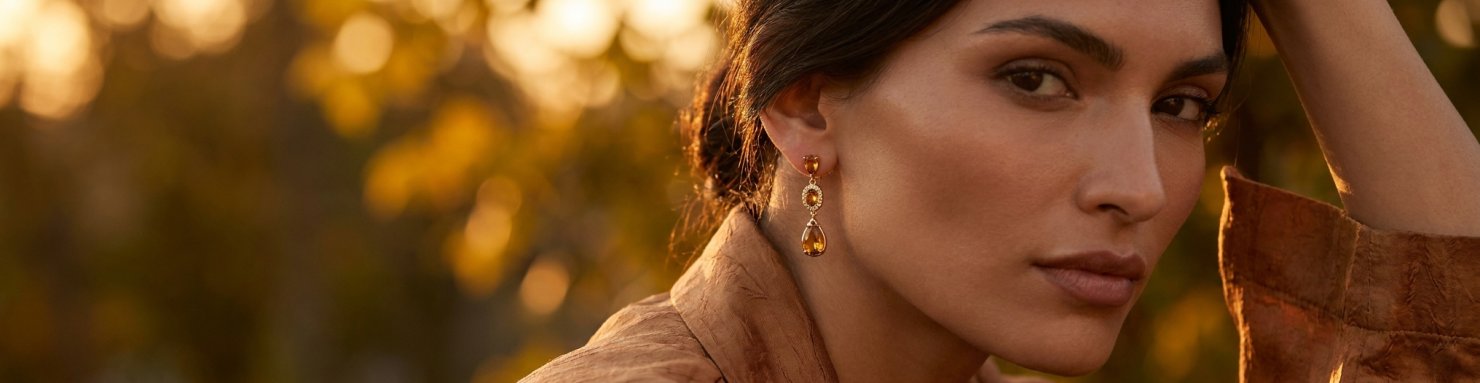 Femme portant des boucles d'oreilles pendantes adaptées à la forme de son visage