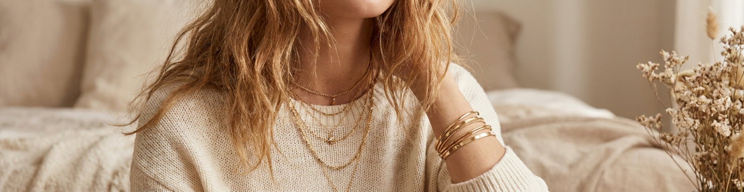 Accumulation de colliers et bracelets fins, bijoux a petit prix superposés